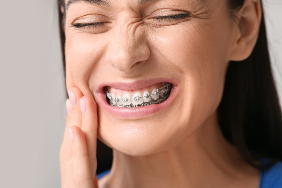 Patient with braces discomfort using orthodontic first aid