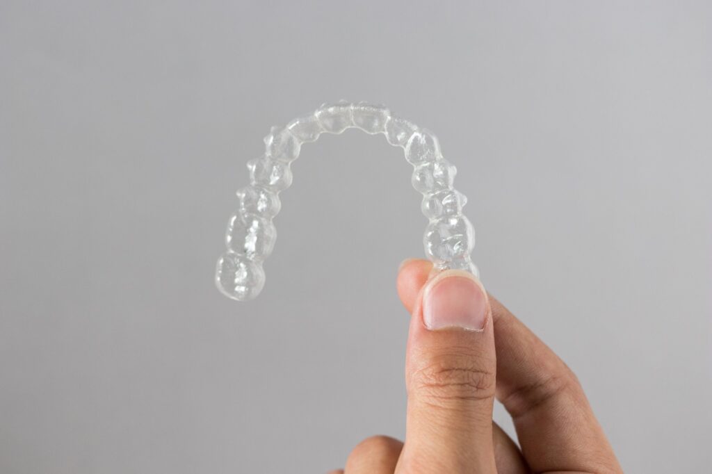 Hands holding clear Invisalign aligners