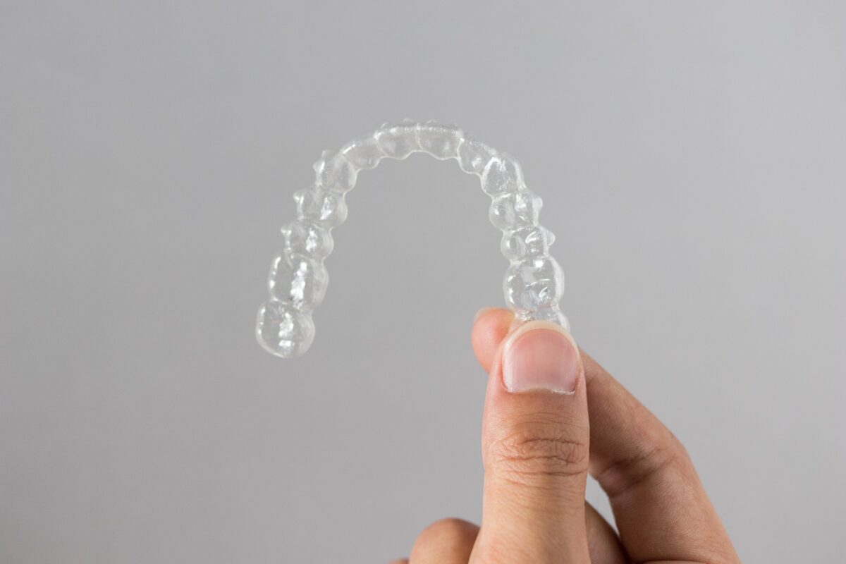 Hands holding clear Invisalign aligners