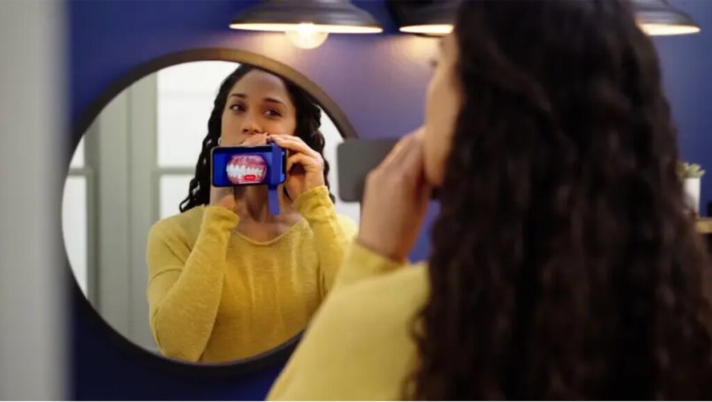 Patient using Grin remote orthodontic monitoring with a smartphone